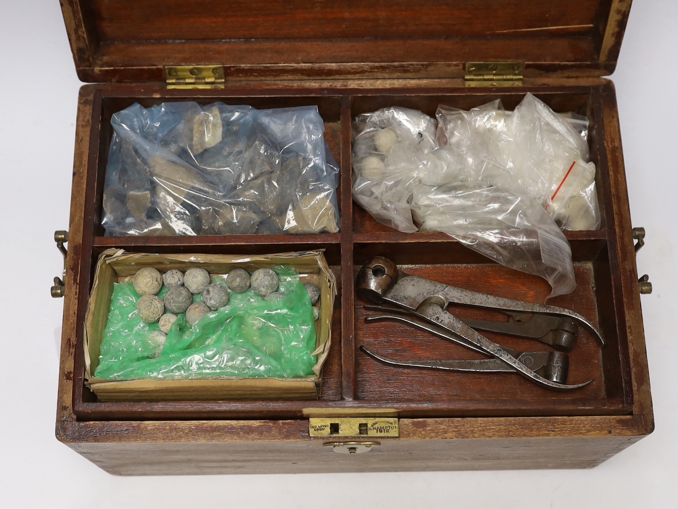 Two mahogany boxes of gun tools, including; bullet moulds, files, a vice, musket balls, etc.